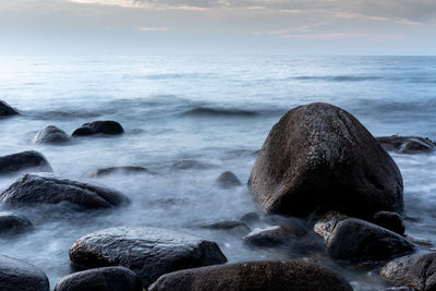 Rocks in sea against sky