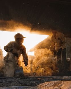 Man working on fire against sky at night