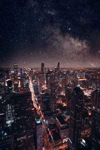 Illuminated cityscape against sky at night