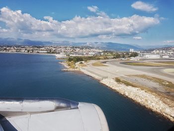 High angle view of city at beach against cloudy sky