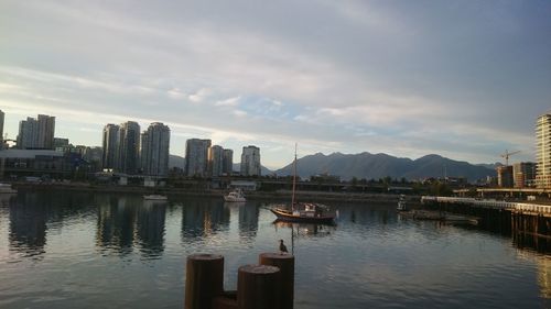 Boats in river with city in background