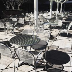 Empty chairs and tables at sidewalk cafe