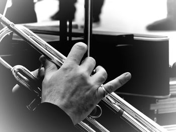 Close-up of cropped hand playing musical instrument