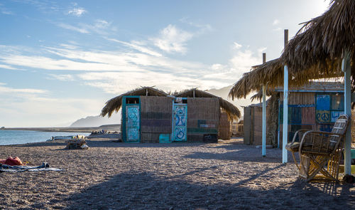 Beach huts by sea against sky