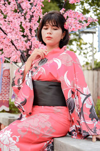 Portrait of young woman sitting on sofa at home