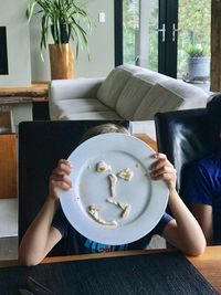 Midsection of woman sitting on sofa at table