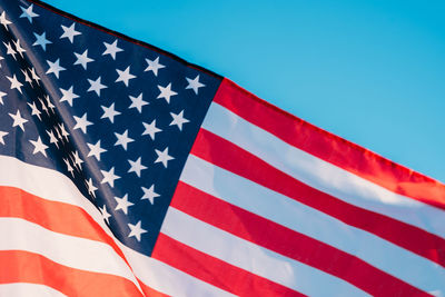 Low angle view of flag against blue sky