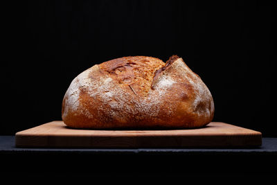 Close-up of bread on table against black background