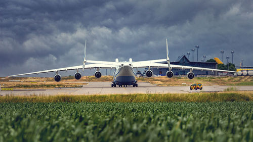 Airplane on airport runway against sky