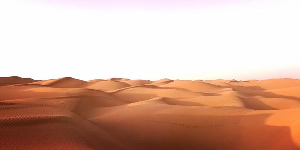 Sand dunes in desert against clear sky