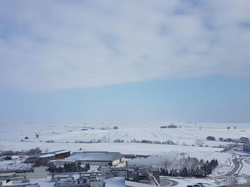 Scenic view of snow covered houses against sky