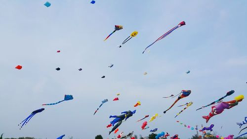 Low angle view of balloons flying against sky