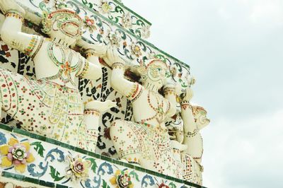 Low angle view of graffiti on wall against sky