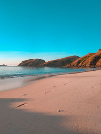 Scenic view of beach against clear blue sky