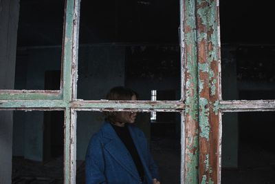 Rear view of woman standing by window