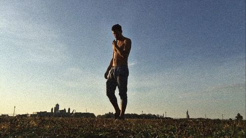 Man standing on field against sky