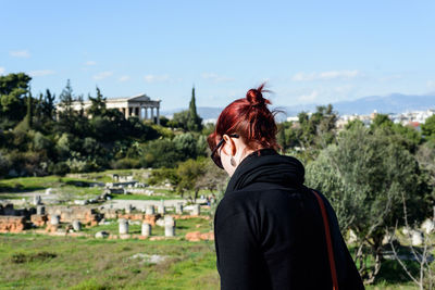 Woman visiting ancient civilization against sky