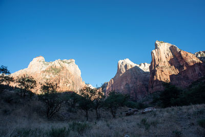 Panoramic view of rocky mountains against clear blue sky