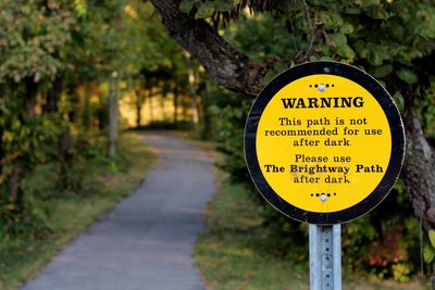 Close-up of warning sign on tree trunk
