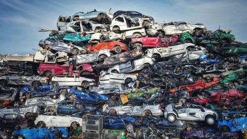 Stack of garbage on metal structure against sky