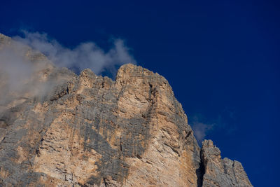 Low angle view of rock formation at tofana di rozes against sky