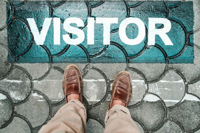 Low section of person standing on footpath