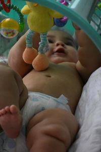 Cute baby boy lying on bed at home