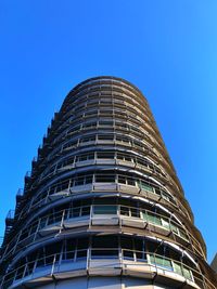 Low angle view of modern building against clear blue sky