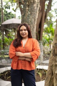 Portrait of young woman standing in forest