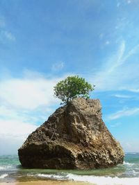 Scenic view of rock formation in sea against sky