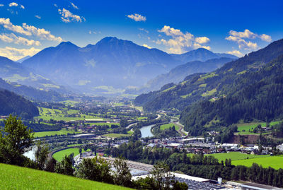 Scenic view of townscape by mountains against sky