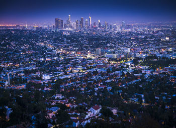 Aerial view of illuminated cityscape against sky at night