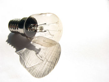 Close-up of light bulb over white background