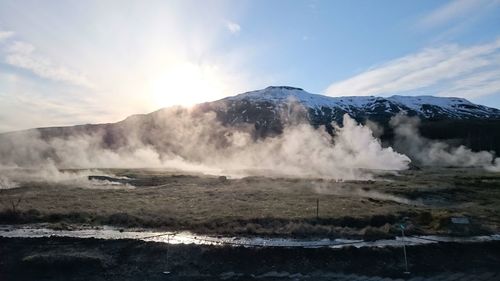 Scenic view of geyser against mountains and sky