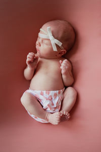 High angle view of baby girl over pink background