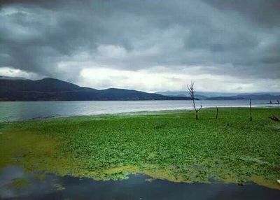 Scenic view of lake against cloudy sky