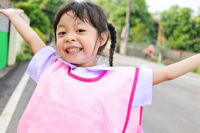 Portrait of smiling girl holding pink outdoors