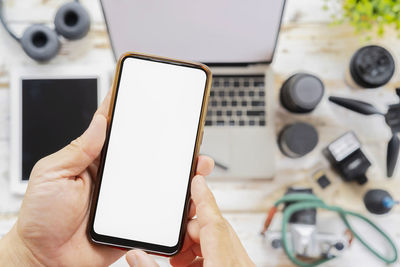 Close-up of person using mobile phone on table