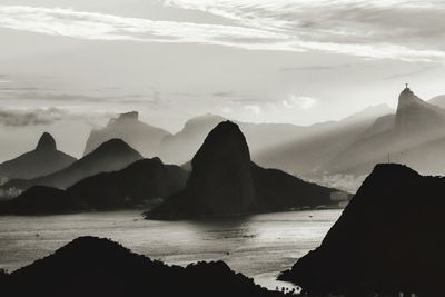 Scenic view of sea and mountains against sky