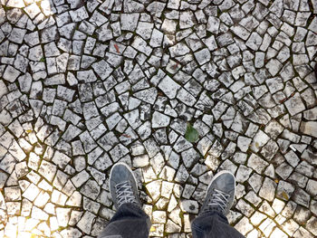 Low section of man standing on cobblestone