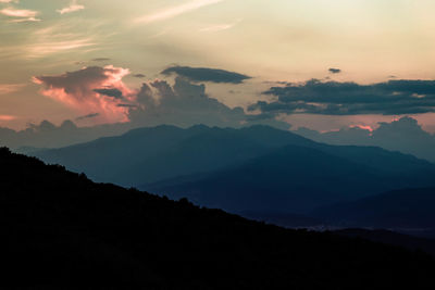 Scenic view of silhouette mountains against sky at sunset