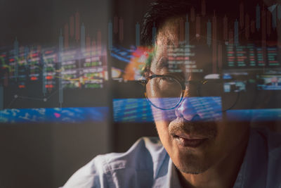 Close up trader working on laptop analyzing online stock market with reflection