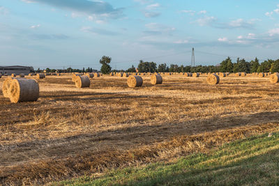 Hay bales on field against sky