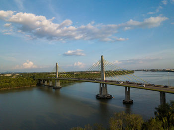 Suspension bridge over river against sky