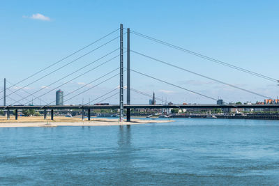 Suspension bridge over river against sky