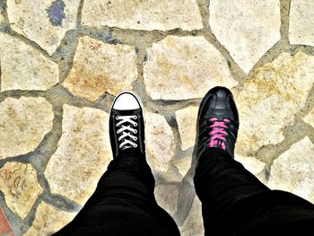 Low section of man standing on cobblestone