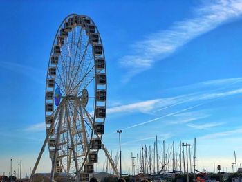 Low angle view of ferris wheel against blue sky