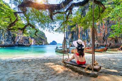 Rear view of woman sitting on beach