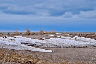 Snow covered field against sky