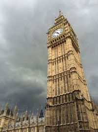 Low angle view of clock tower against cloudy sky